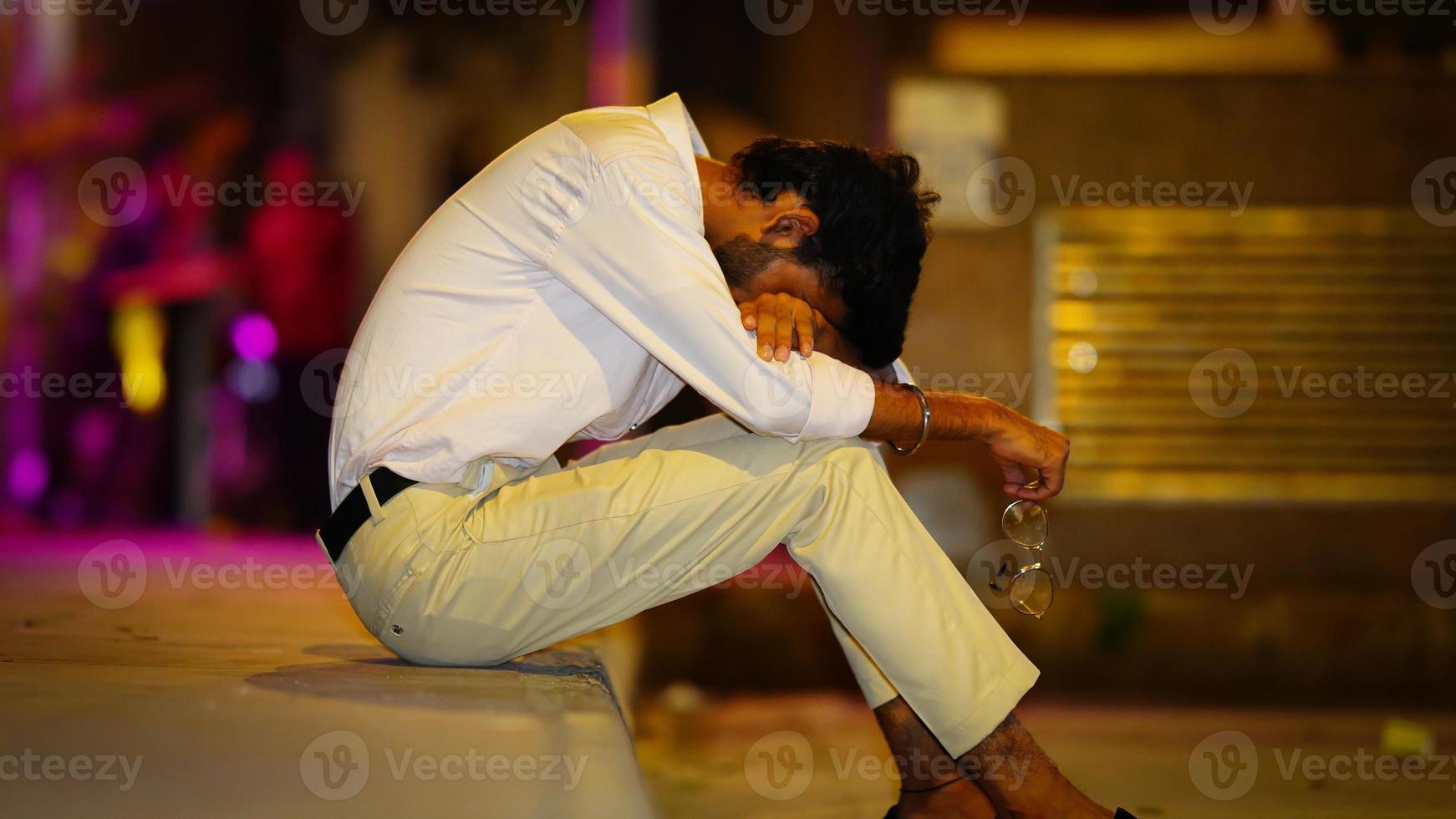 sad man sitting in road side photo