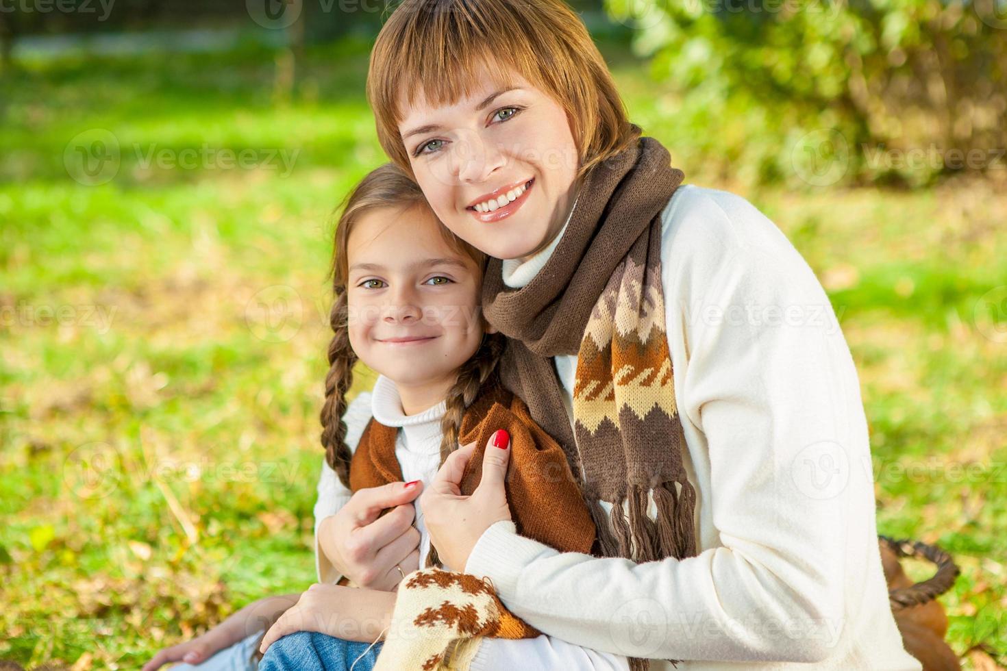 feliz madre con hija pequeña en el parque otoño foto