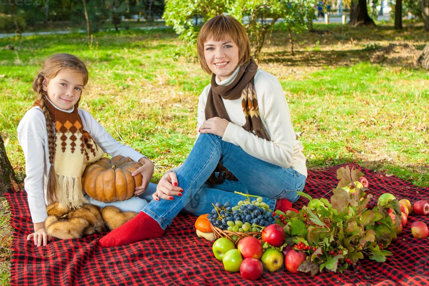 feliz madre con hija pequeña en el parque otoño foto