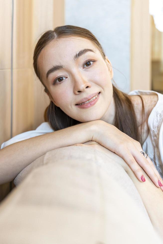 Beautiful caucasian woman lying down the sofa bed and looking at the camera with close up shot for skin care and cosmetics usage purpose with copy space photo