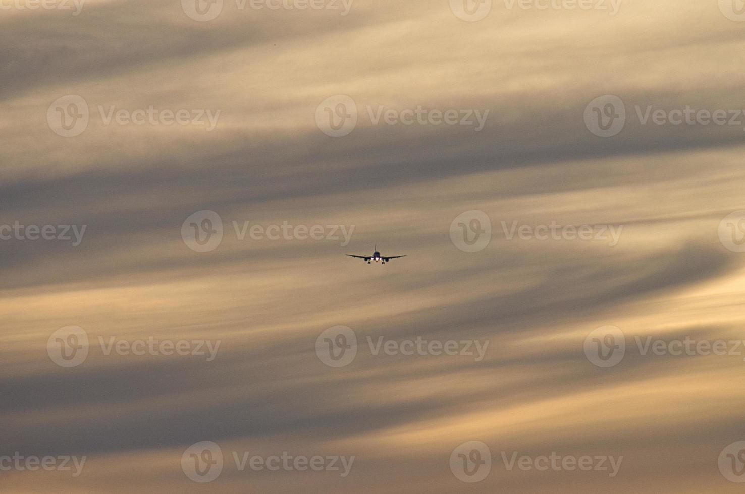 airplane in the evening sky in luminous horizon. photo