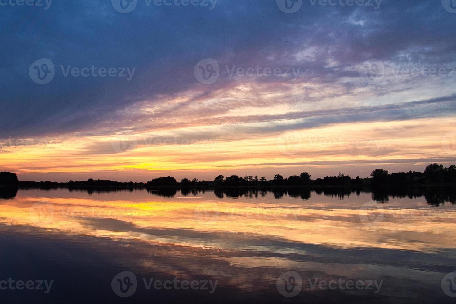 Reflection of the sky in the water. gold, yellow and pink colors of the sky are reflected in the lake. photo