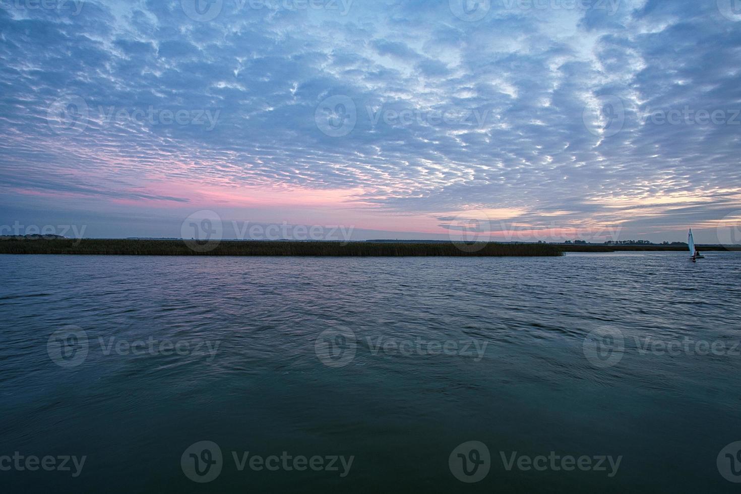 from the harbor in zingst the bodden view with burning sky photo