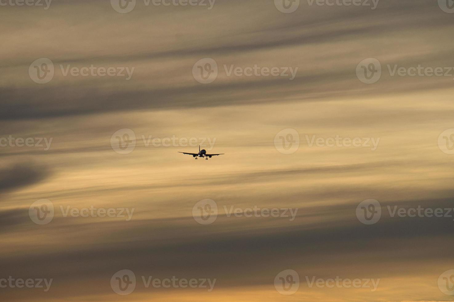 airplane in the evening sky in luminous horizon. photo