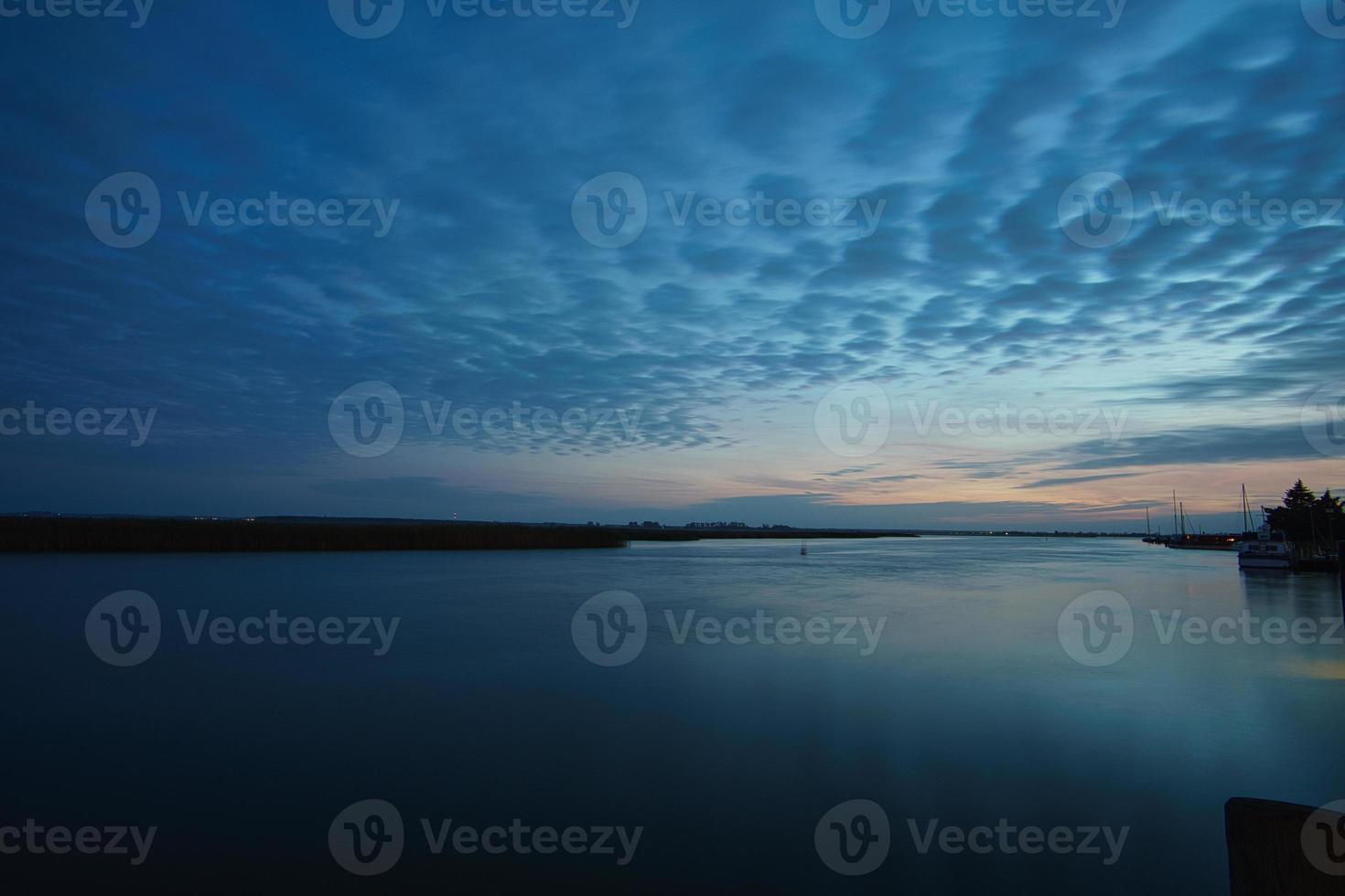 from the harbor in zingst the bodden view with burning sky photo