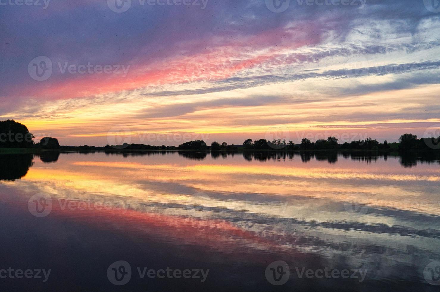 Reflection of the sky in the water. gold, yellow and pink colors of the sky are reflected in the lake. photo