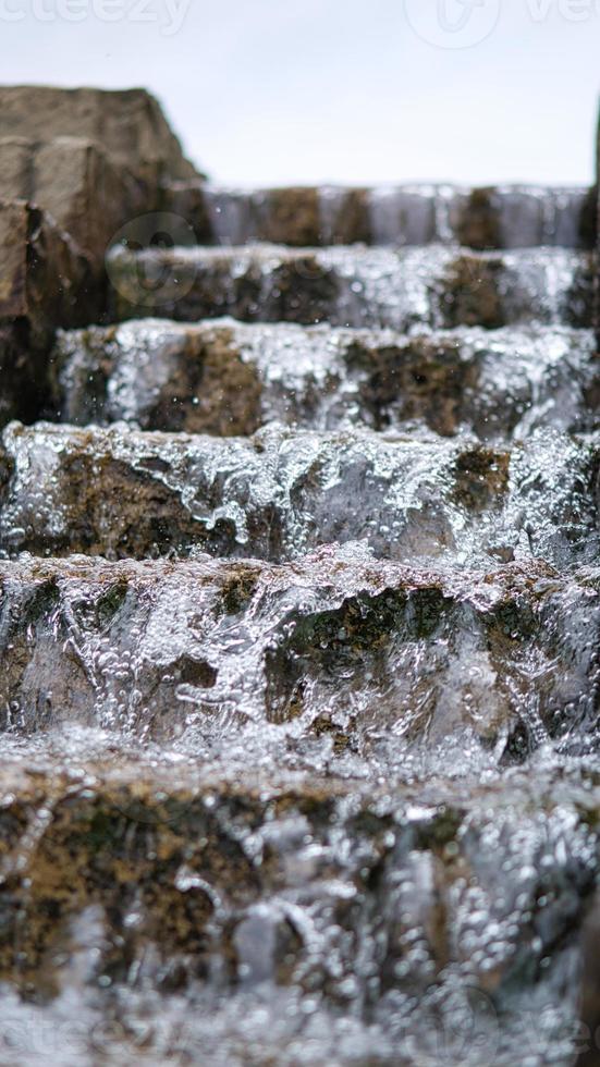 waterfall over a stone staircase. a stream flowing through a park. photo