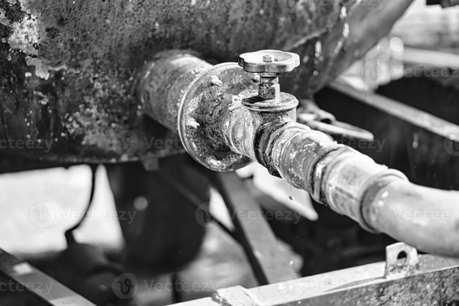 Dripping tap of a water tank in the open . Drops fall from the pipe photo