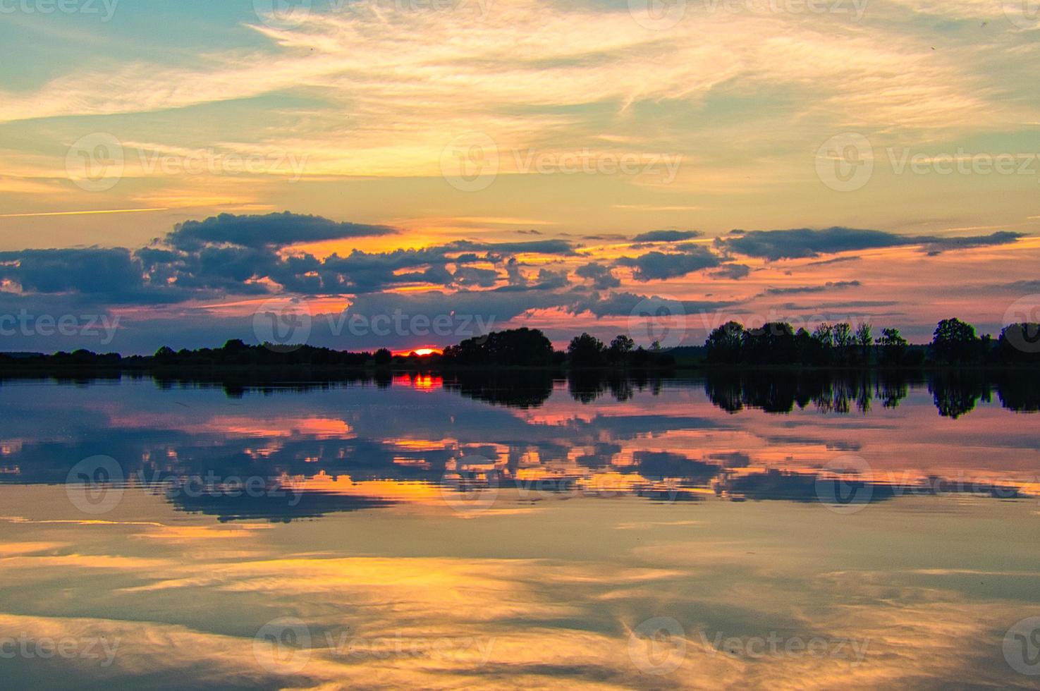 Reflection of the sky in the water. gold, yellow and pink colors of the sky are reflected in the lake. photo