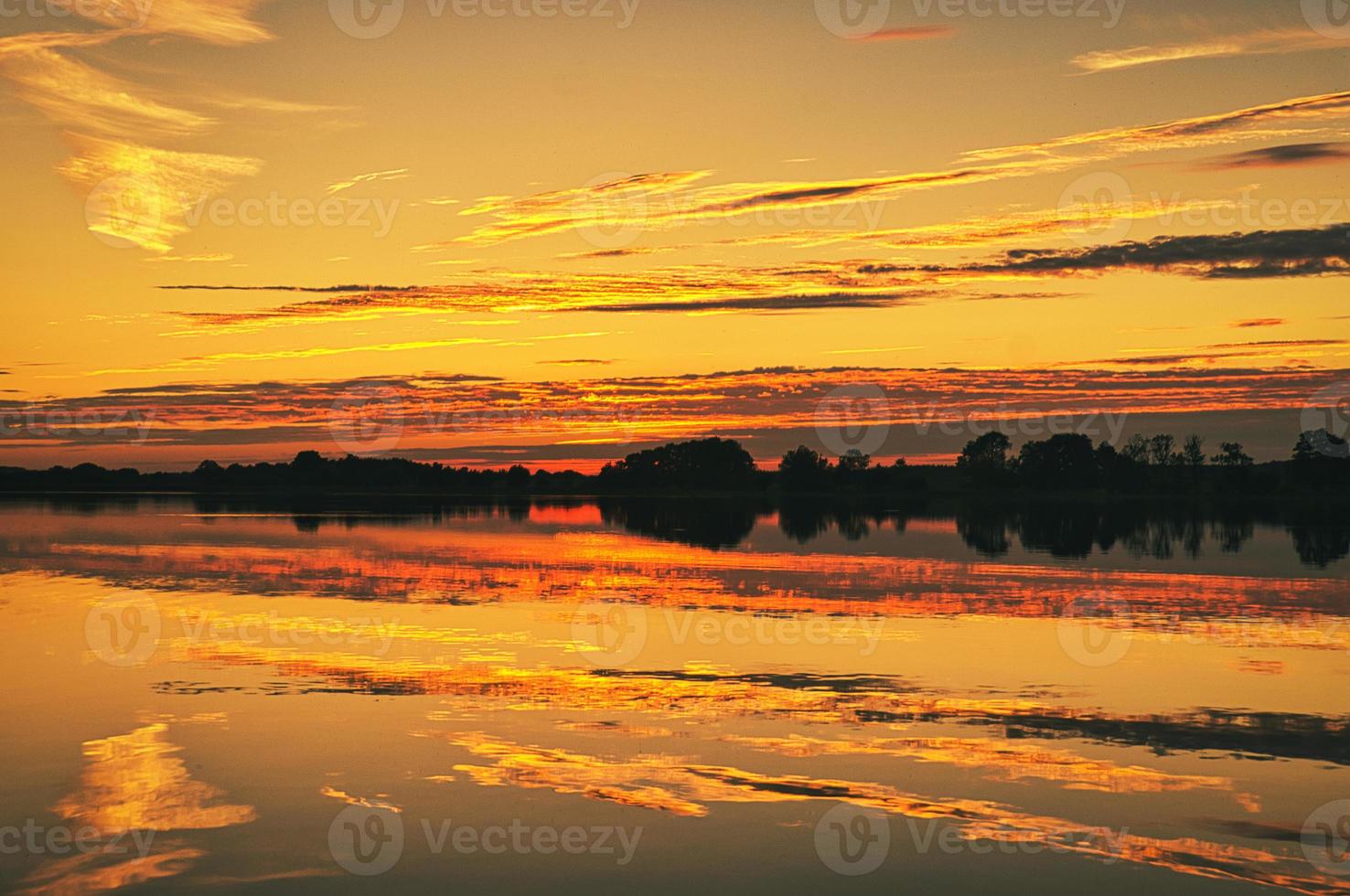 reflection of the sky in the water. gold, yellow and pink colors of the sky are reflected in the lake. photo