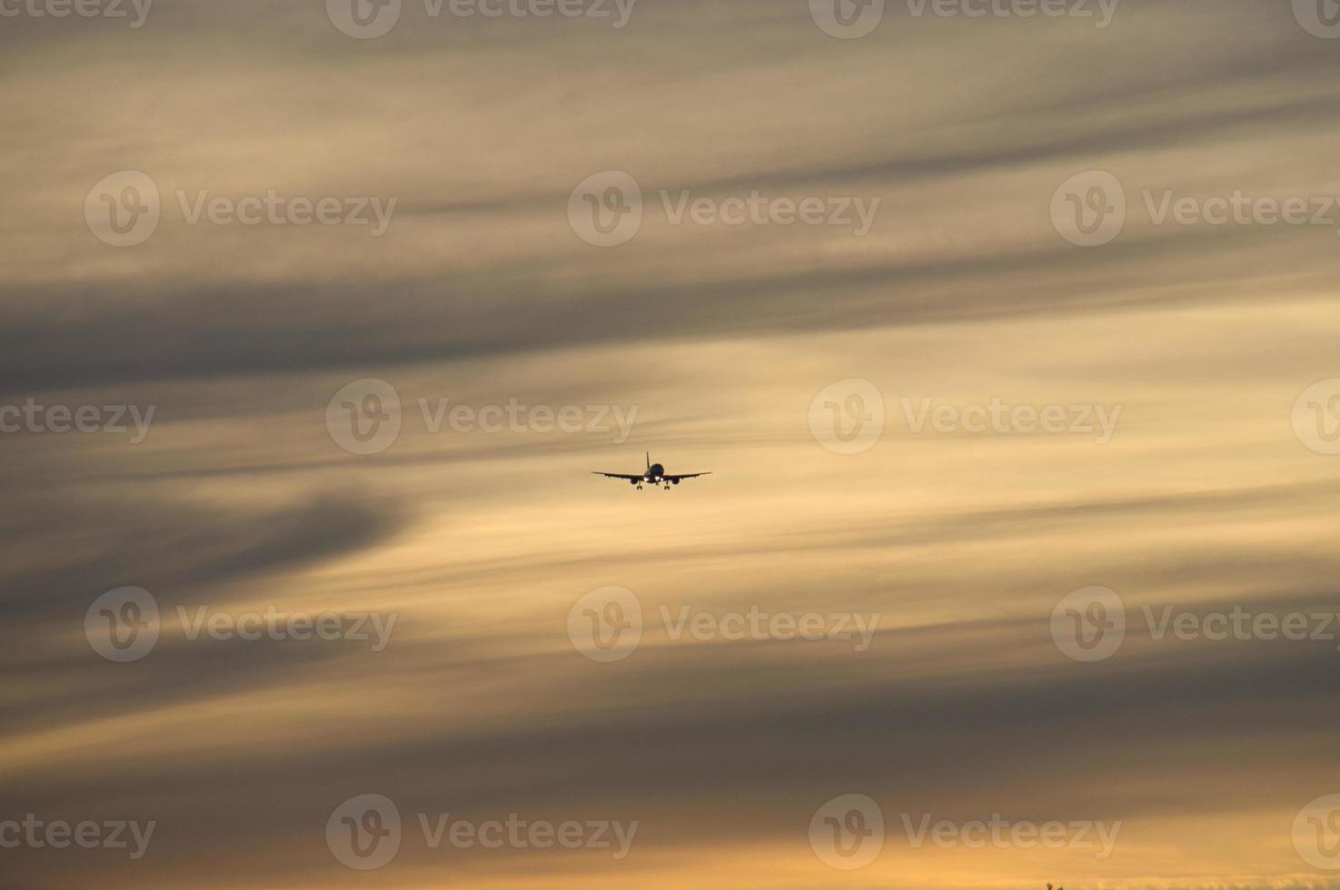 Plane in the evening sky in luminous horizon. It goes on vacation photo