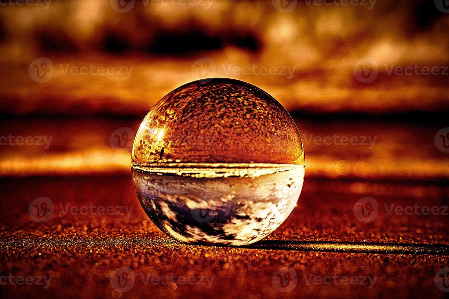 Abstract representation of a glass ball on the beach at the Baltic Sea. photo