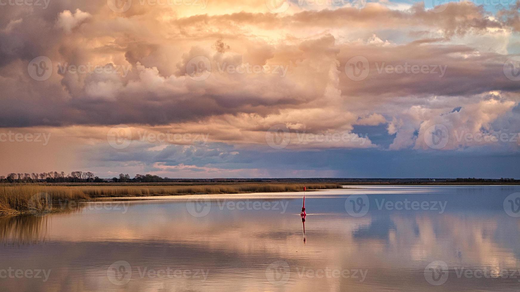 The Bodden landscape of Zingst with dramatic sky and reflection in the water photo