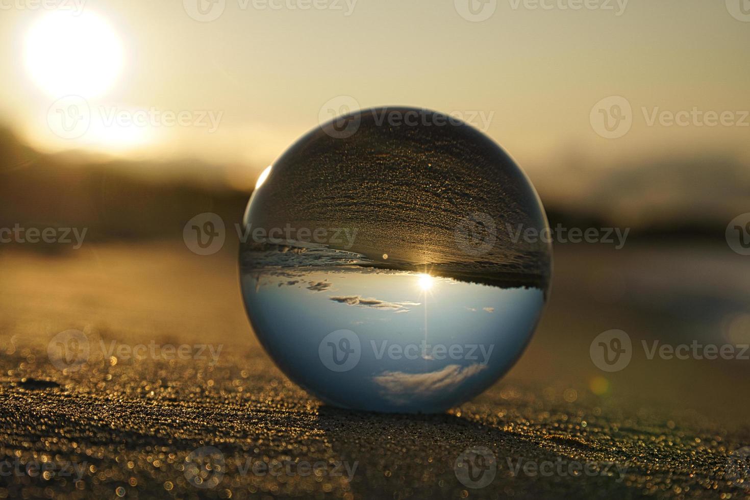 Glass globe on the beach of the Baltic Sea in Zingst in which the landscape is depicted. photo