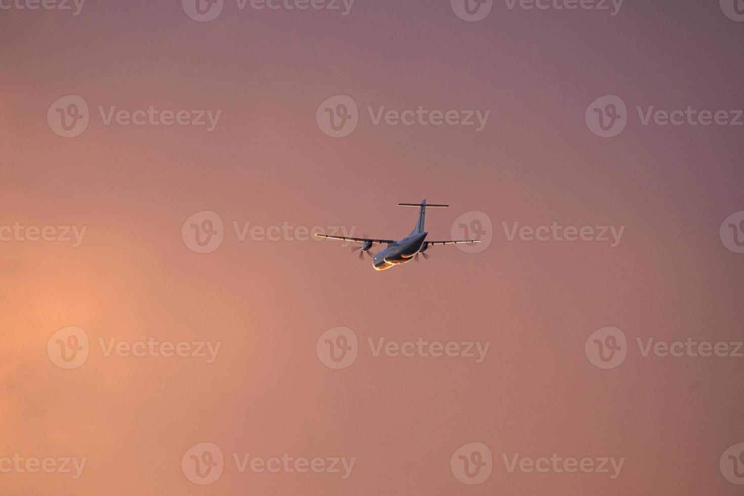 Plane in the evening sky in luminous horizon. It goes on vacation photo