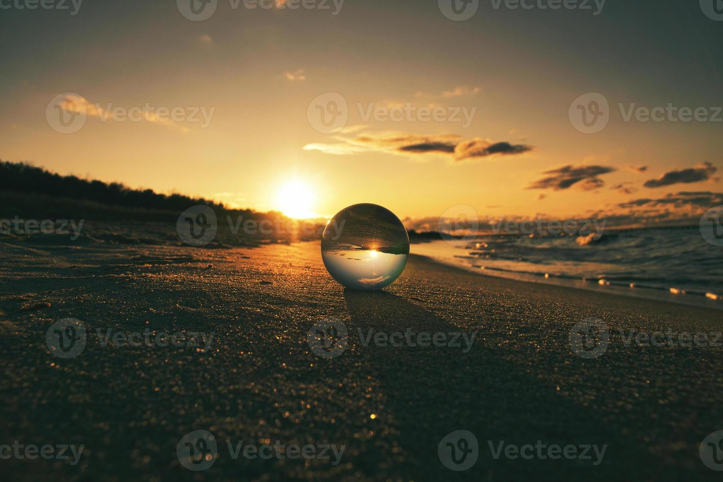 Glass globe on the beach of the Baltic Sea in Zingst in which the landscape is depicted. photo