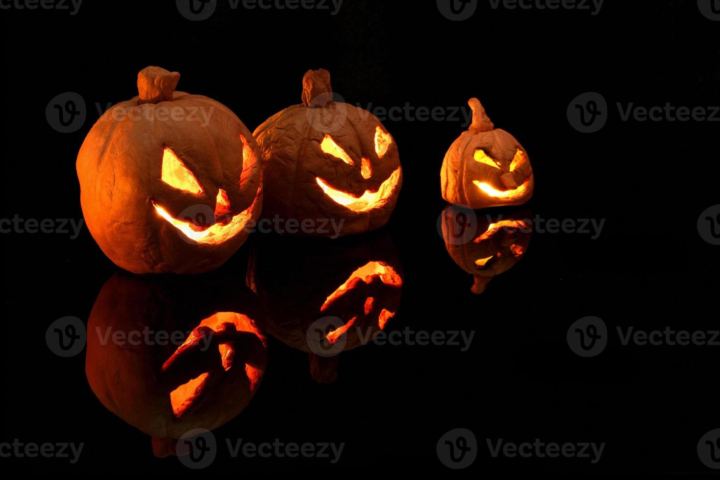 Halloween pumpkin with burning candles on black background photo
