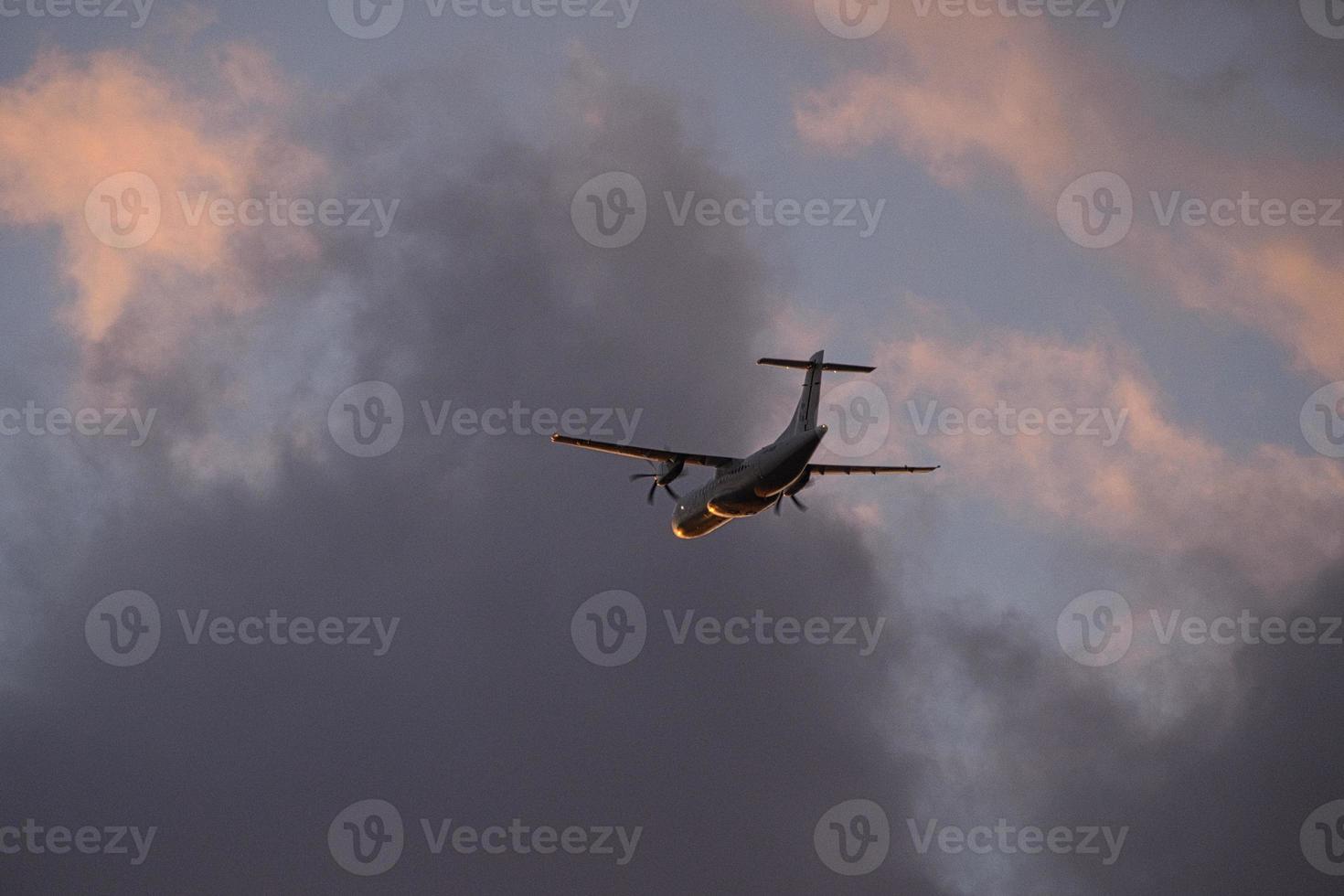 airplane in the evening sky in luminous horizon. photo