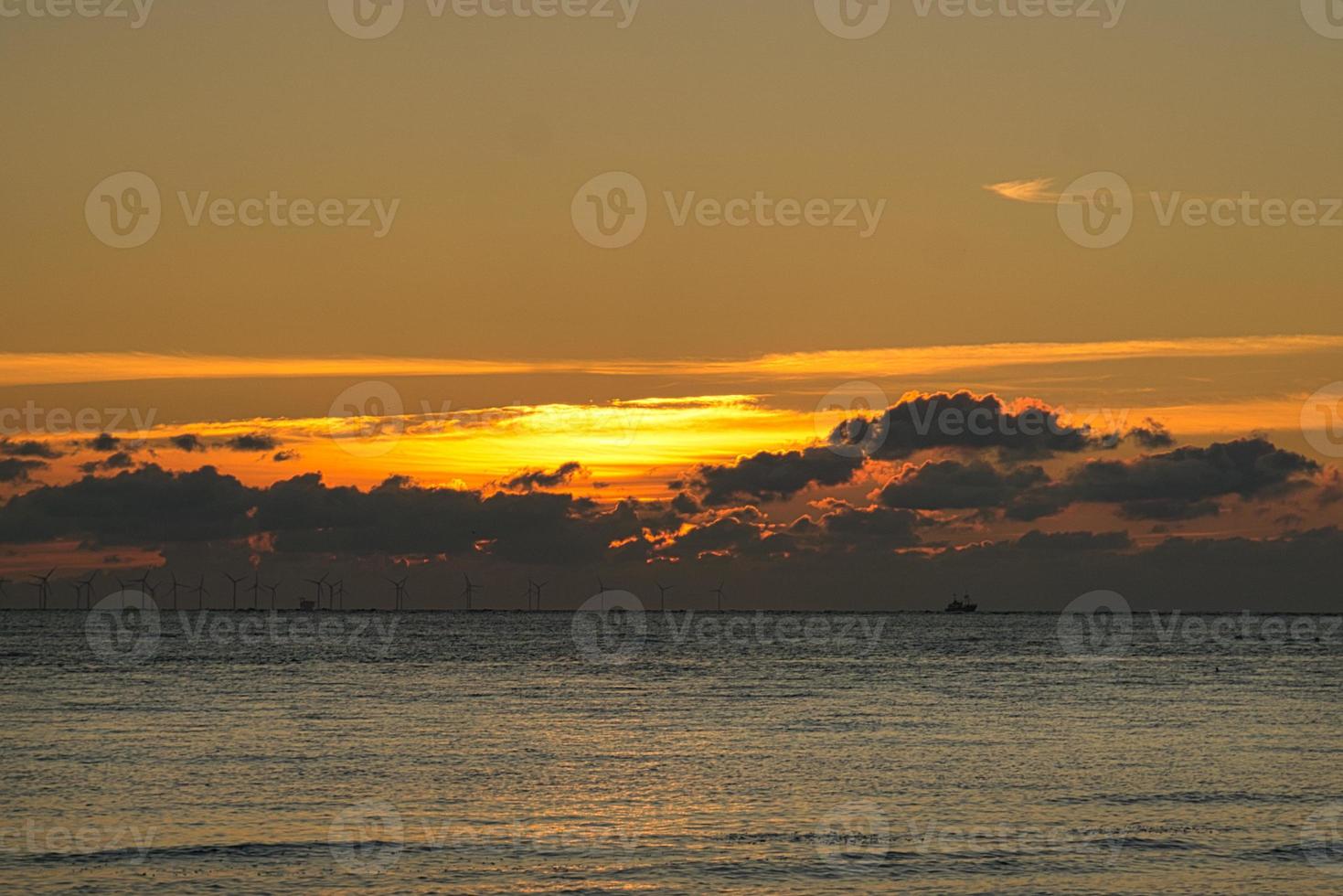 Sunset by the sea in colorful light show in the clouds photo