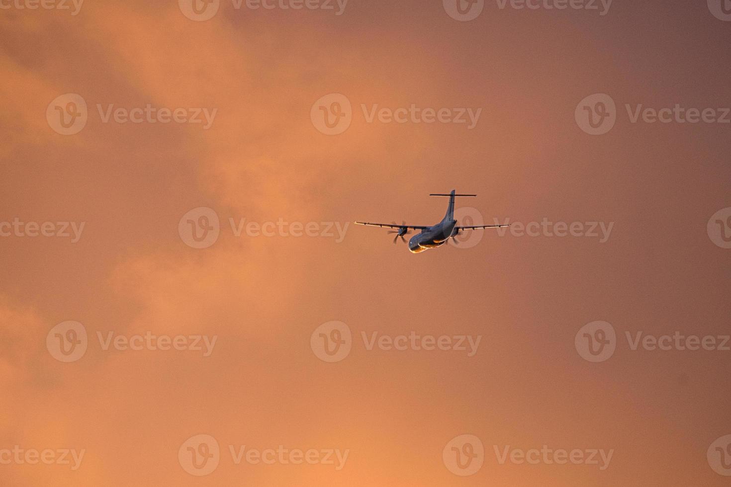 airplane in the evening sky in luminous horizon. photo