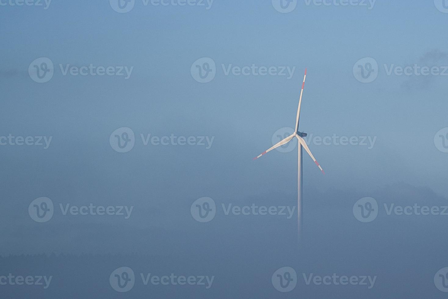 molino de viento en un paisaje brumoso. energía renovable para un futuro con conciencia ambiental foto