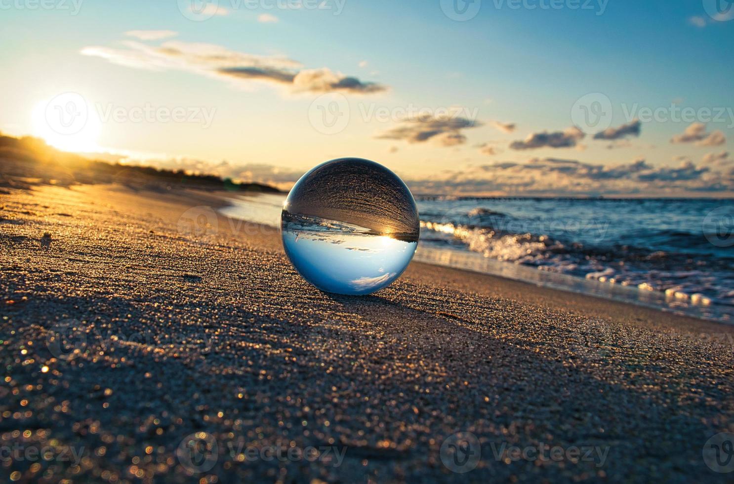Glass globe on the beach of the Baltic Sea in Zingst in which the landscape is depicted. photo
