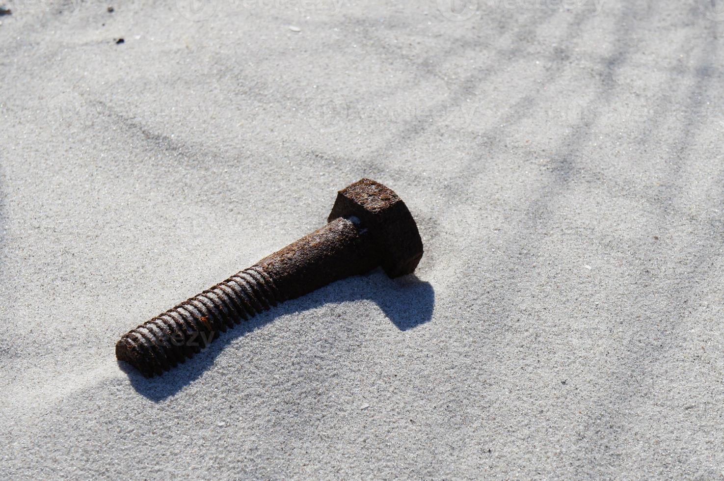 tornillo oxidado en la playa foto