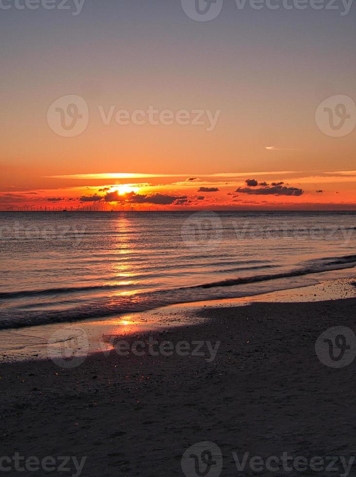 puesta de sol junto al mar en un colorido juego de luces en las nubes. blavand dinamarca. foto