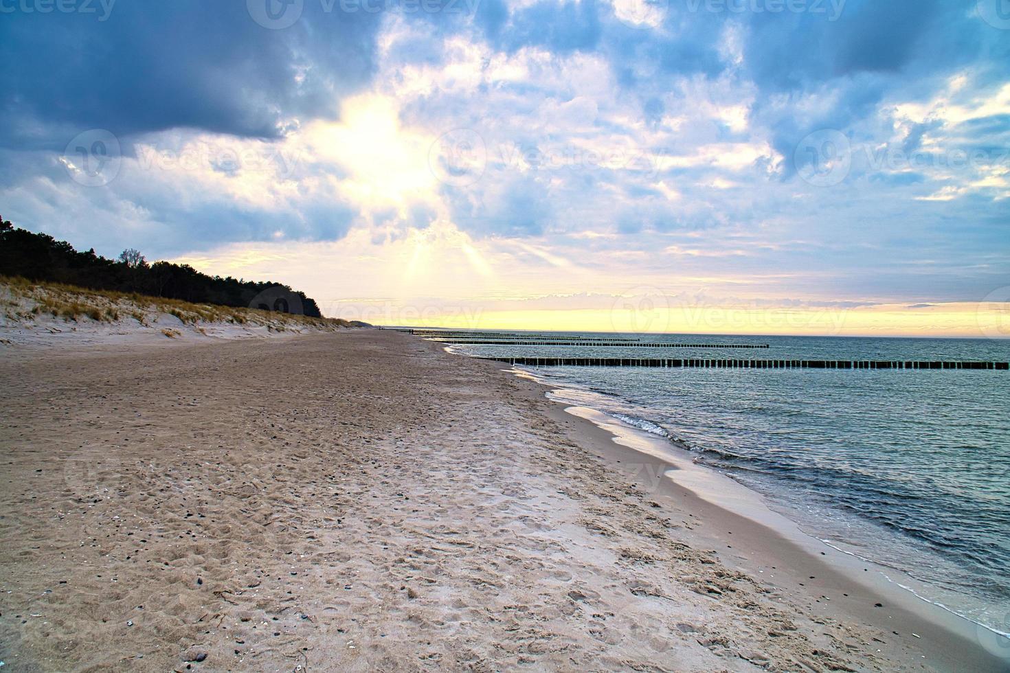 On the beach of the Baltic Sea. Sunset, groynes, beach and sand. Landscape shot photo