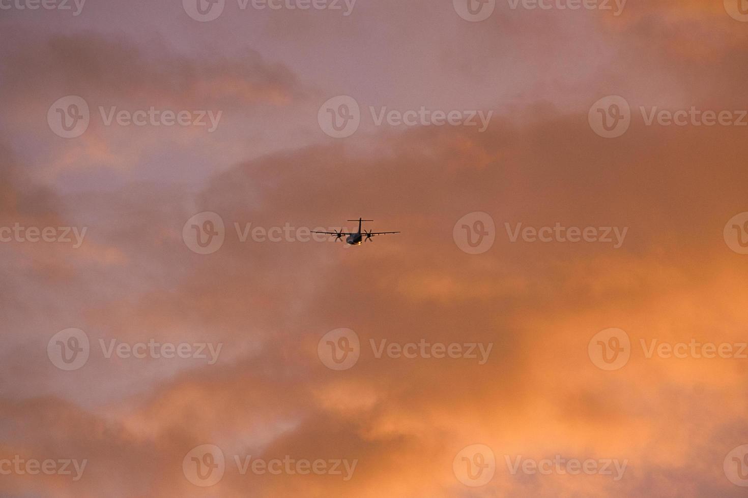 airplane in the evening sky in luminous horizon. photo