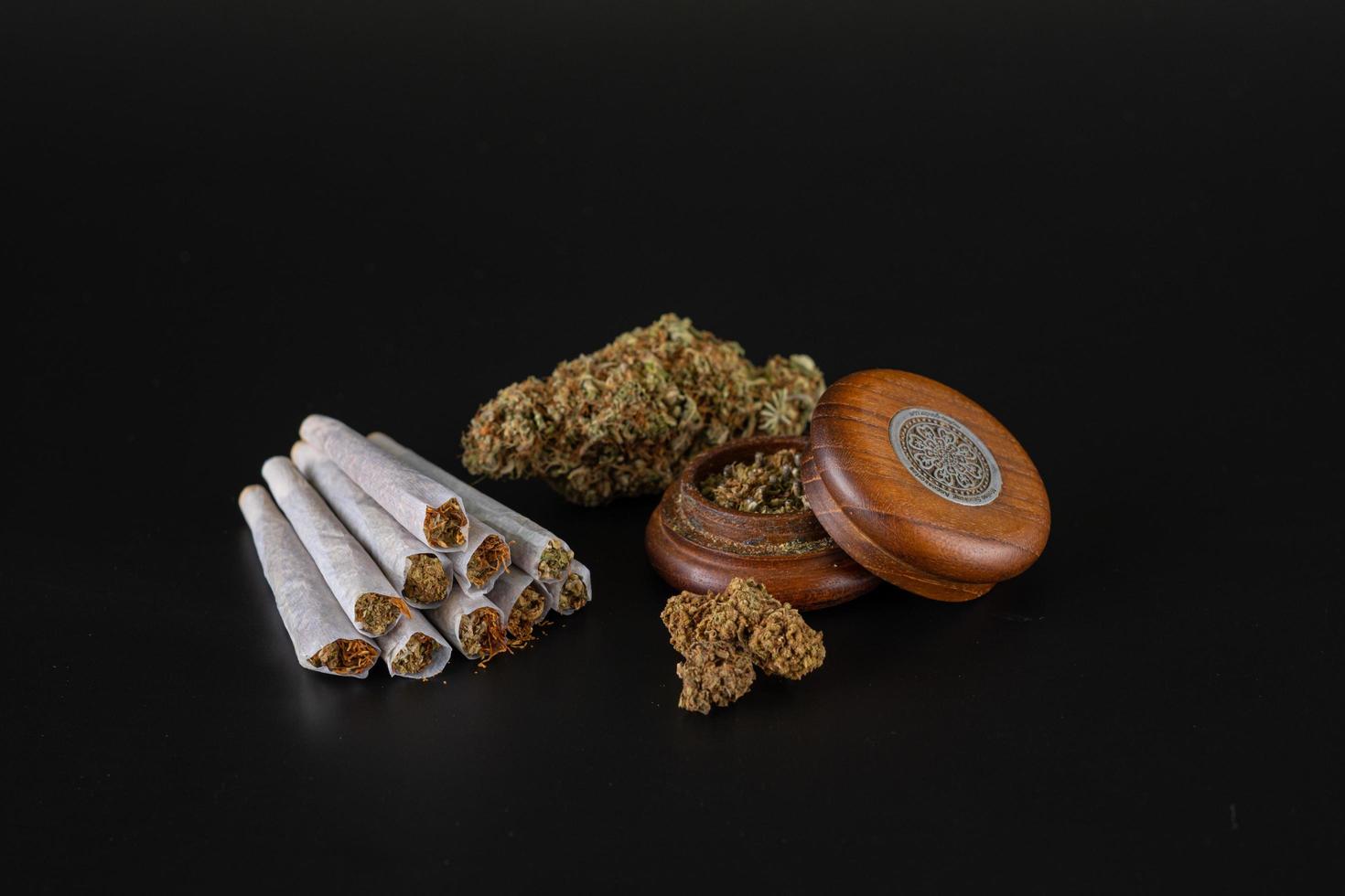 bud, mountain of joints and full grinder on a black background photo