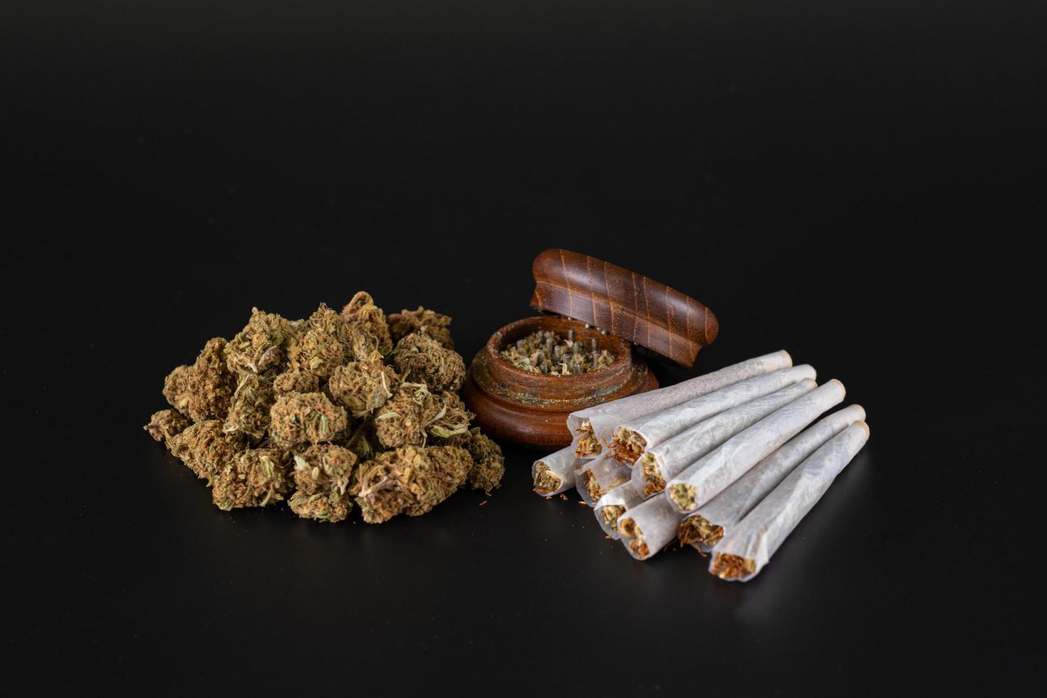 bunch of small buds ready to roll with full ginder and rolled joints photo