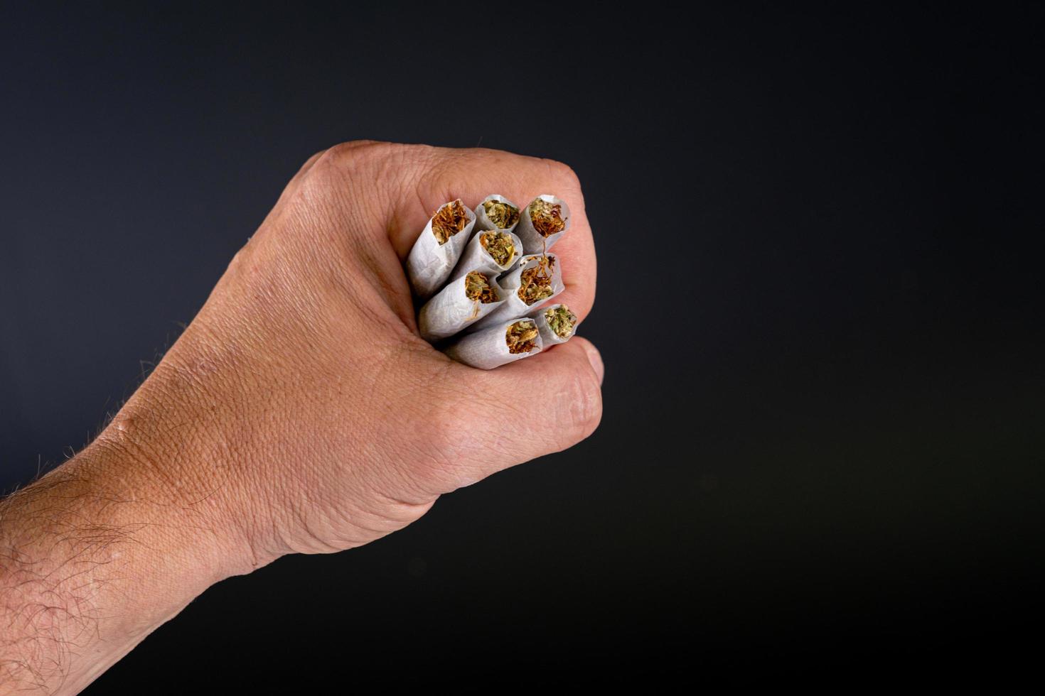 handful of marijuana joints in a hand photo