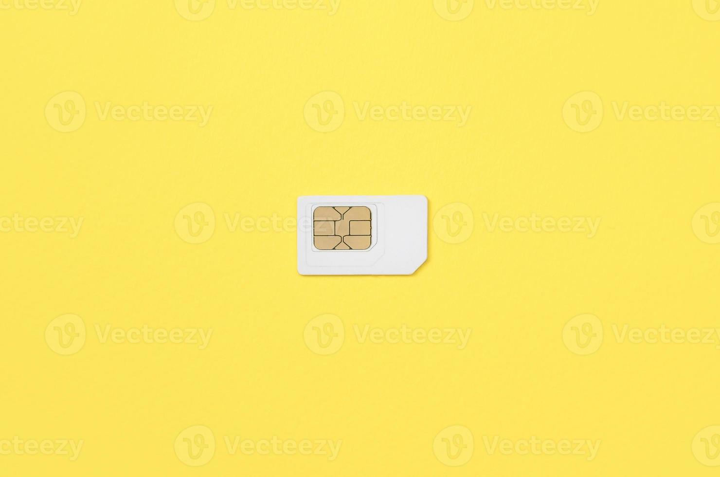 Subscriber identity module. White SIM card on yellow background photo