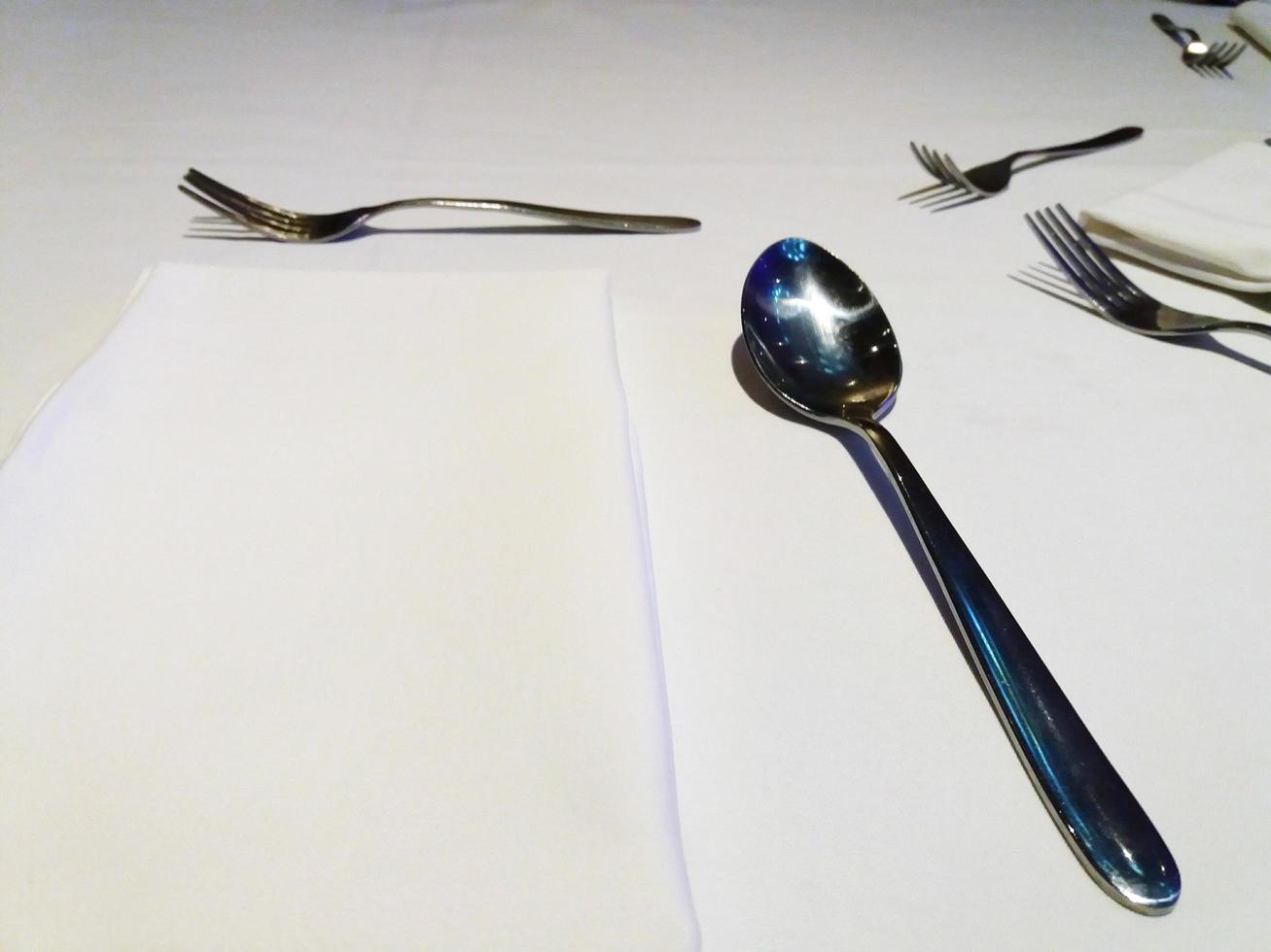 Spoon and fork on white table with copy space photo
