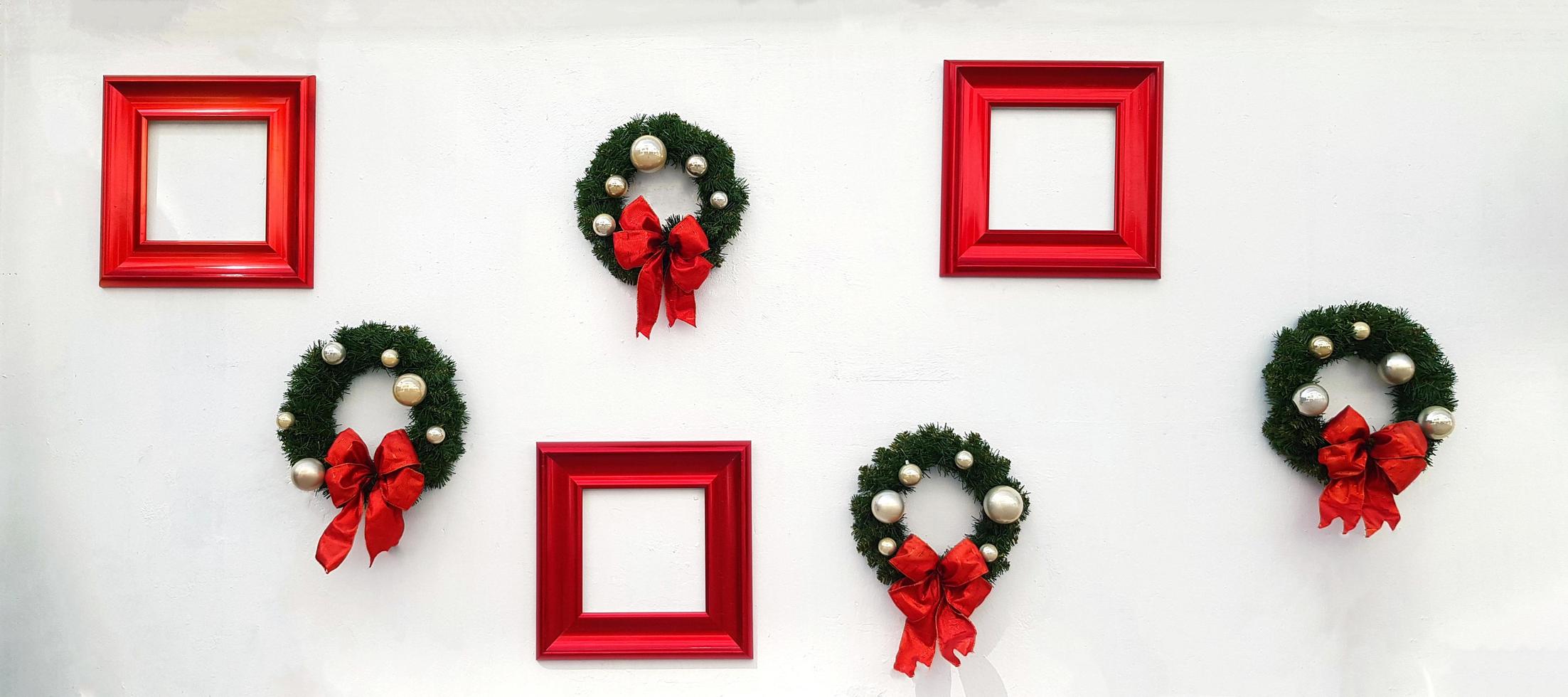 Christmas, happy new year wreath decoration with red ribbon, white ball and red picture frame for add wording isolated on white wall background. Object for decorated party, festival with copy space. photo