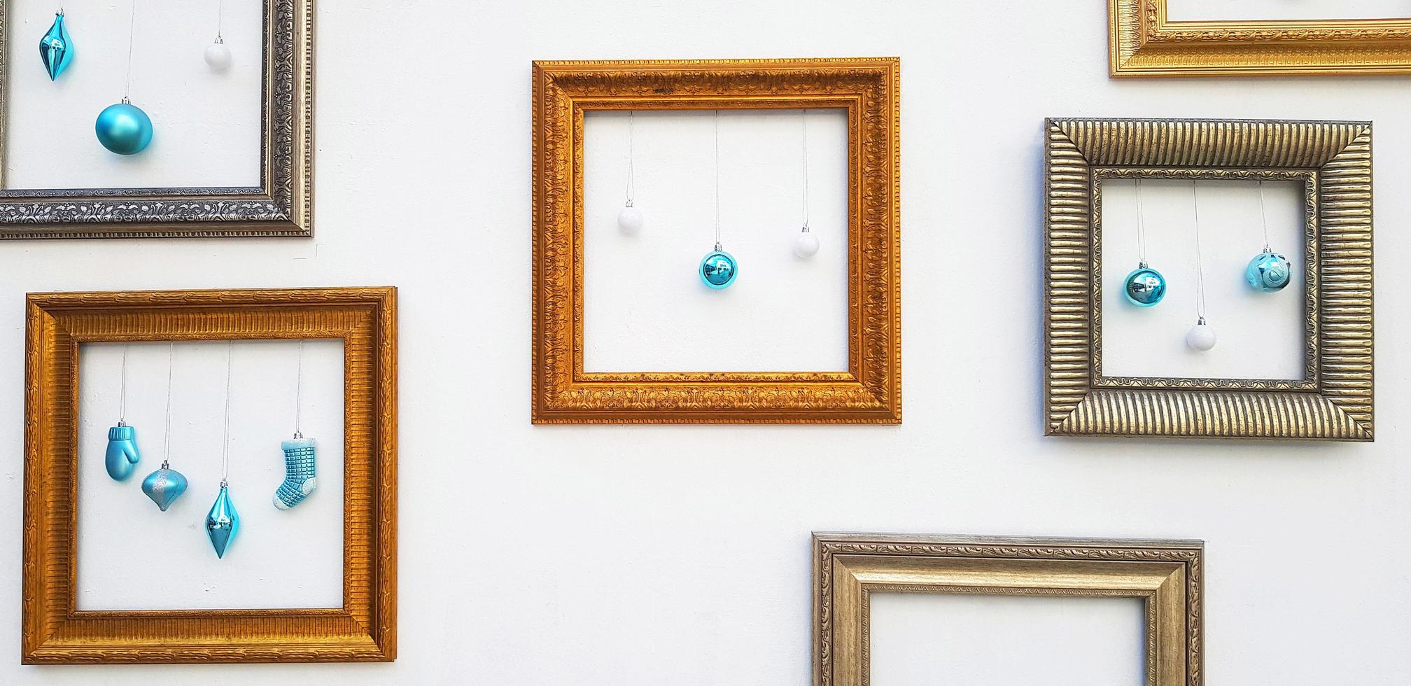 Many Yellow or Golden, brown picture frame mockup with blue ball and light bulb hanging on white concrete wall with copy space. Framework on background. Decorate for festival, Celebrate party. photo