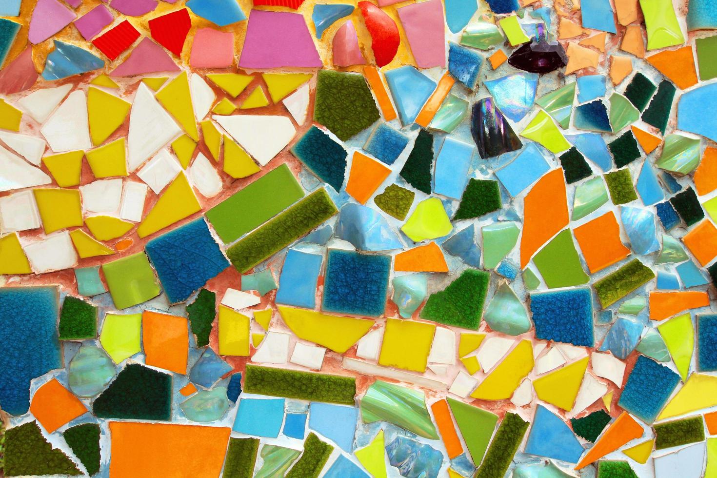 colorido de fondo de mosaico abstracto en la pared. arte de papel tapiz de azulejos rojos, naranjas, azules, negros, blancos, marrones rosados y violetas o púrpuras rotos o agrietados. foto