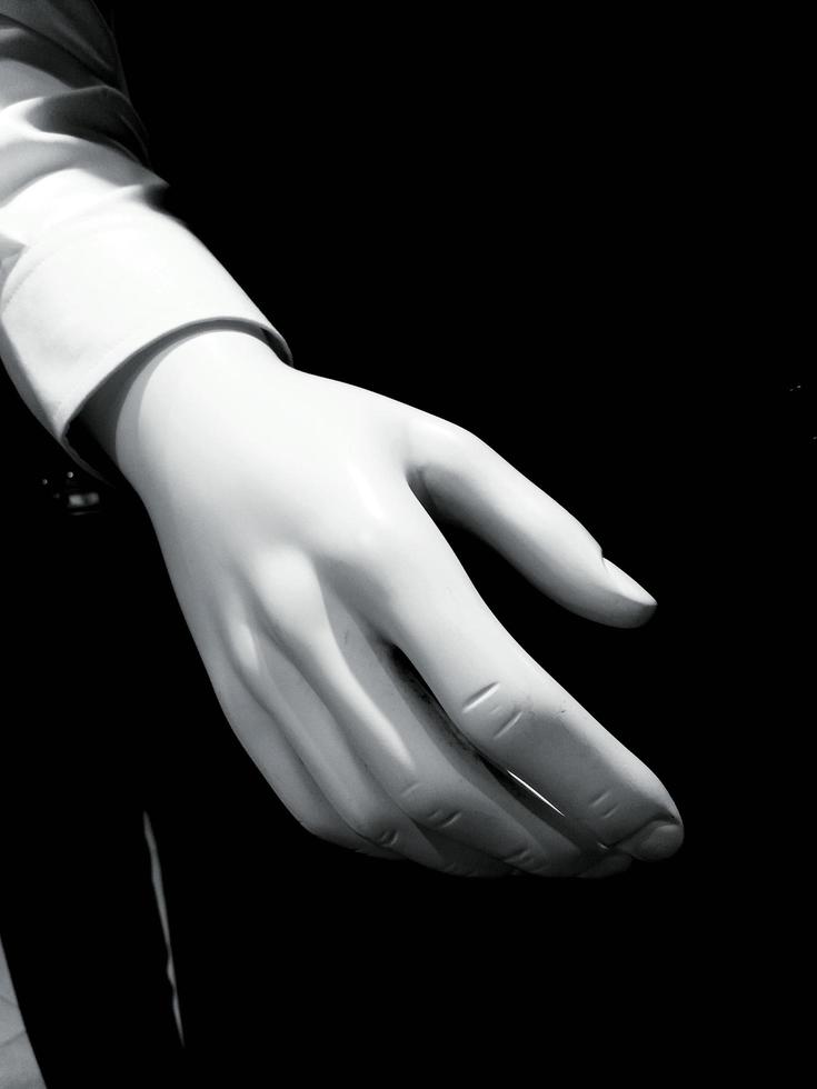 Close up white hand of mannequin with black background and copy space at shirt store. photo