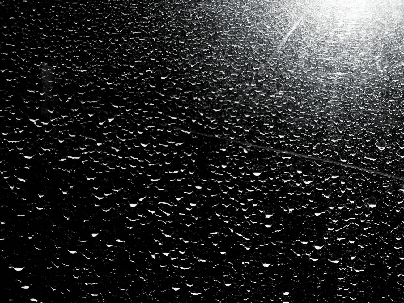 plumero o gota de lluvia en la puerta de metal con luz en estilo blanco y negro. fondo y concepto texturizado foto