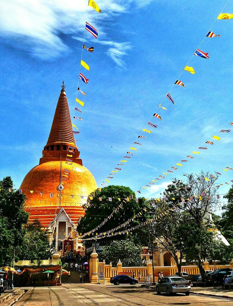 Big pagoda with Thai flag and blue sky background. Ancient architecture and Exterior design. photo