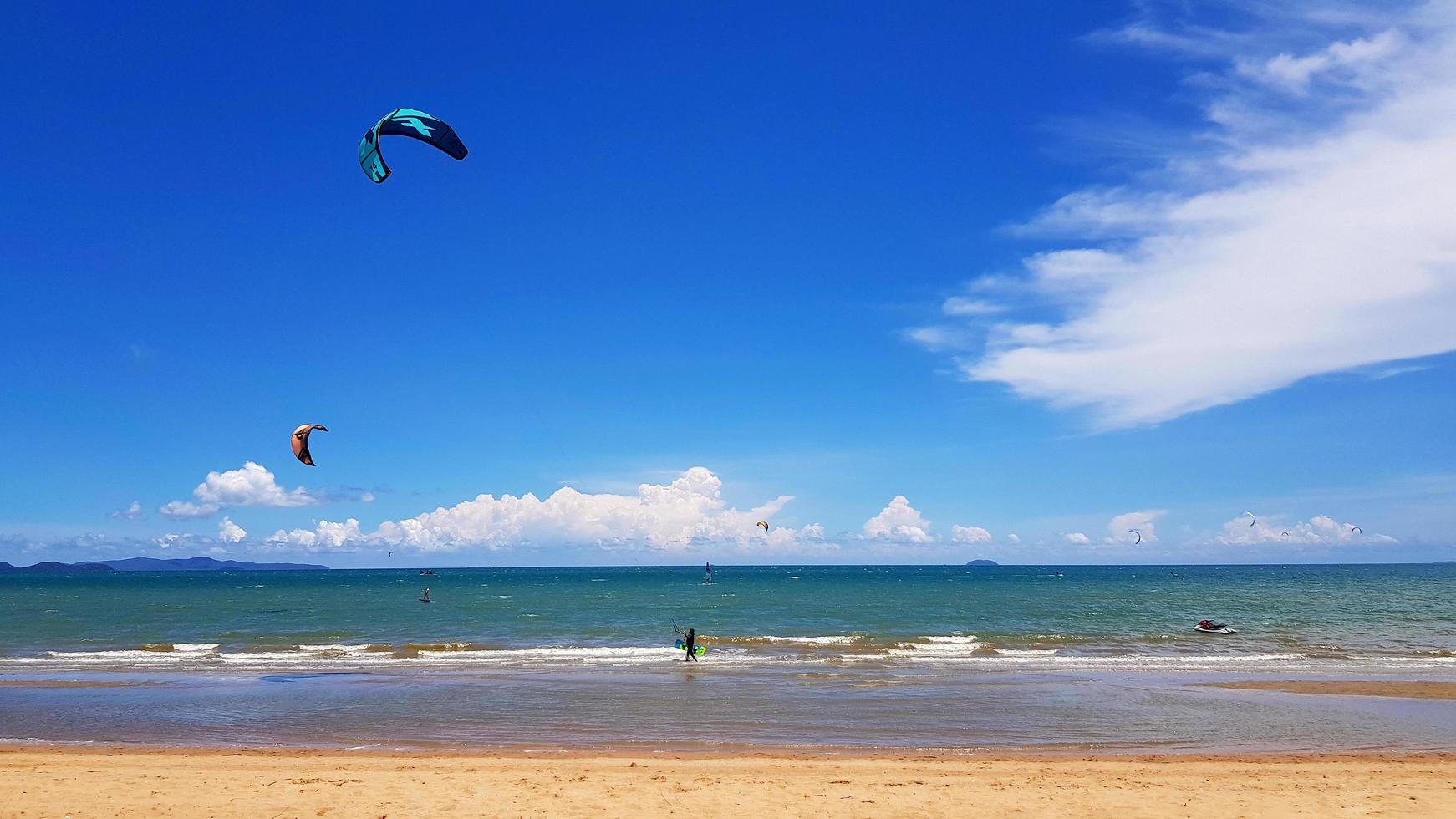 Many people sitting on sofa and taking picture with blue sky background at cafe or restaurant decorated with pink tone such as seat and umbrella on the beach. photo