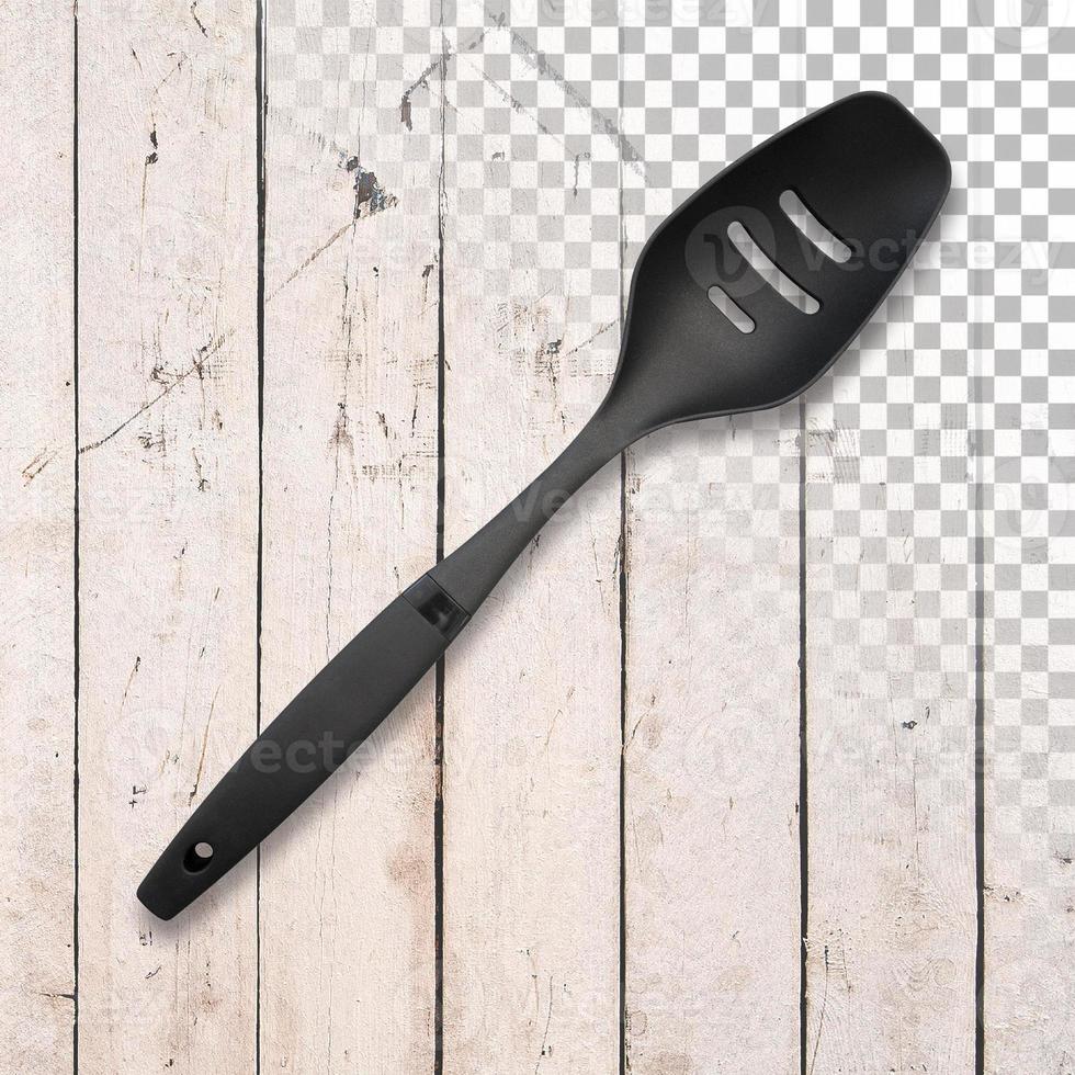 Black silicone chef's spatula on a transparent wooden background. photo