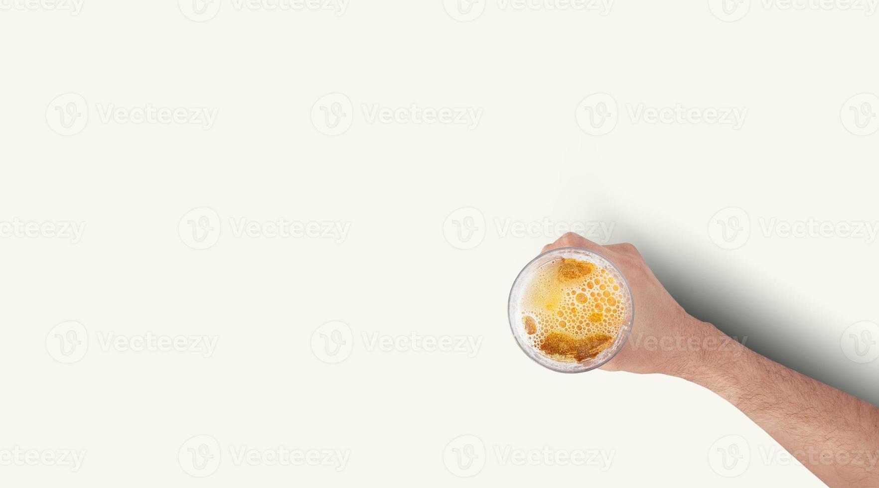 Mano de hombre sosteniendo la taza llena de cerveza sobre fondo blanco. vista superior aislada. foto