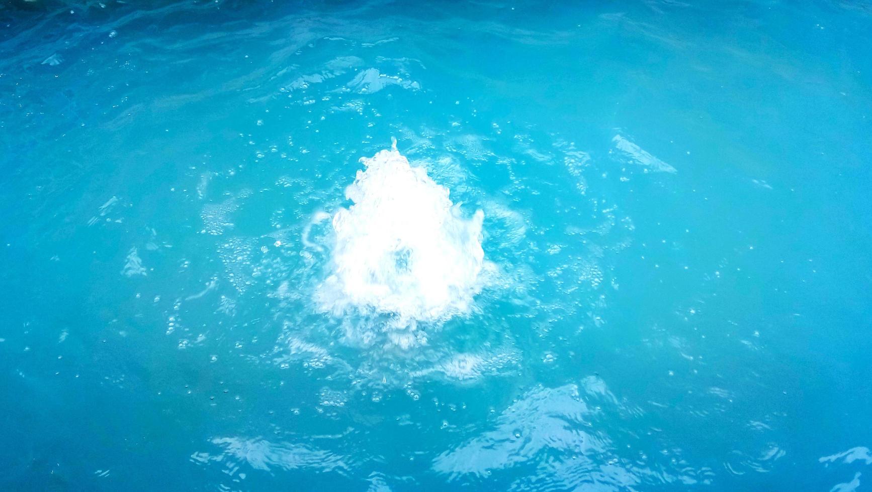 Water surface with ripples and sunrays reflections photo