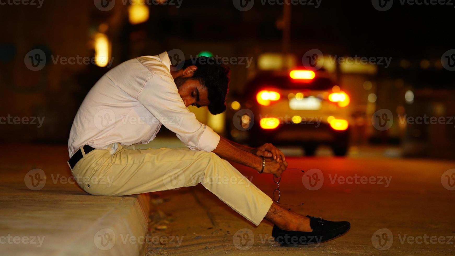 portrait of sad man sitting in road side and wear formal dress photo