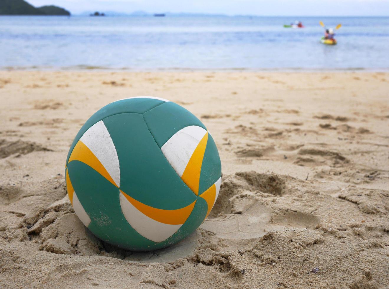 cerrar un voleibol de playa en la arena con fondo de mar foto