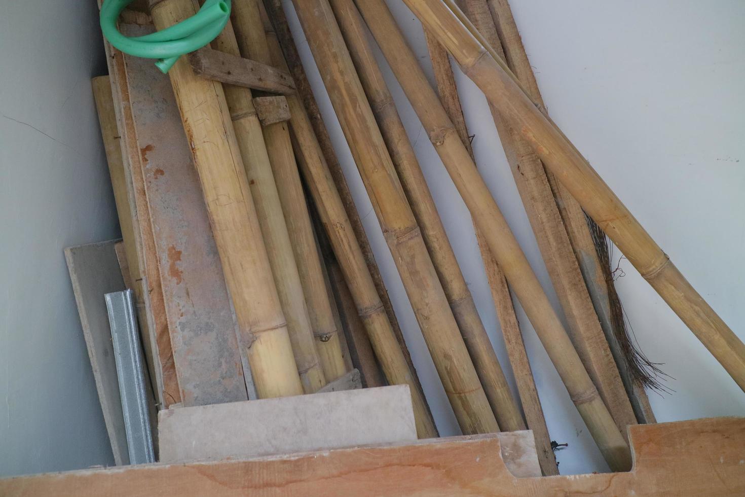 montón de tablas usadas y bambú en la esquina de la habitación foto