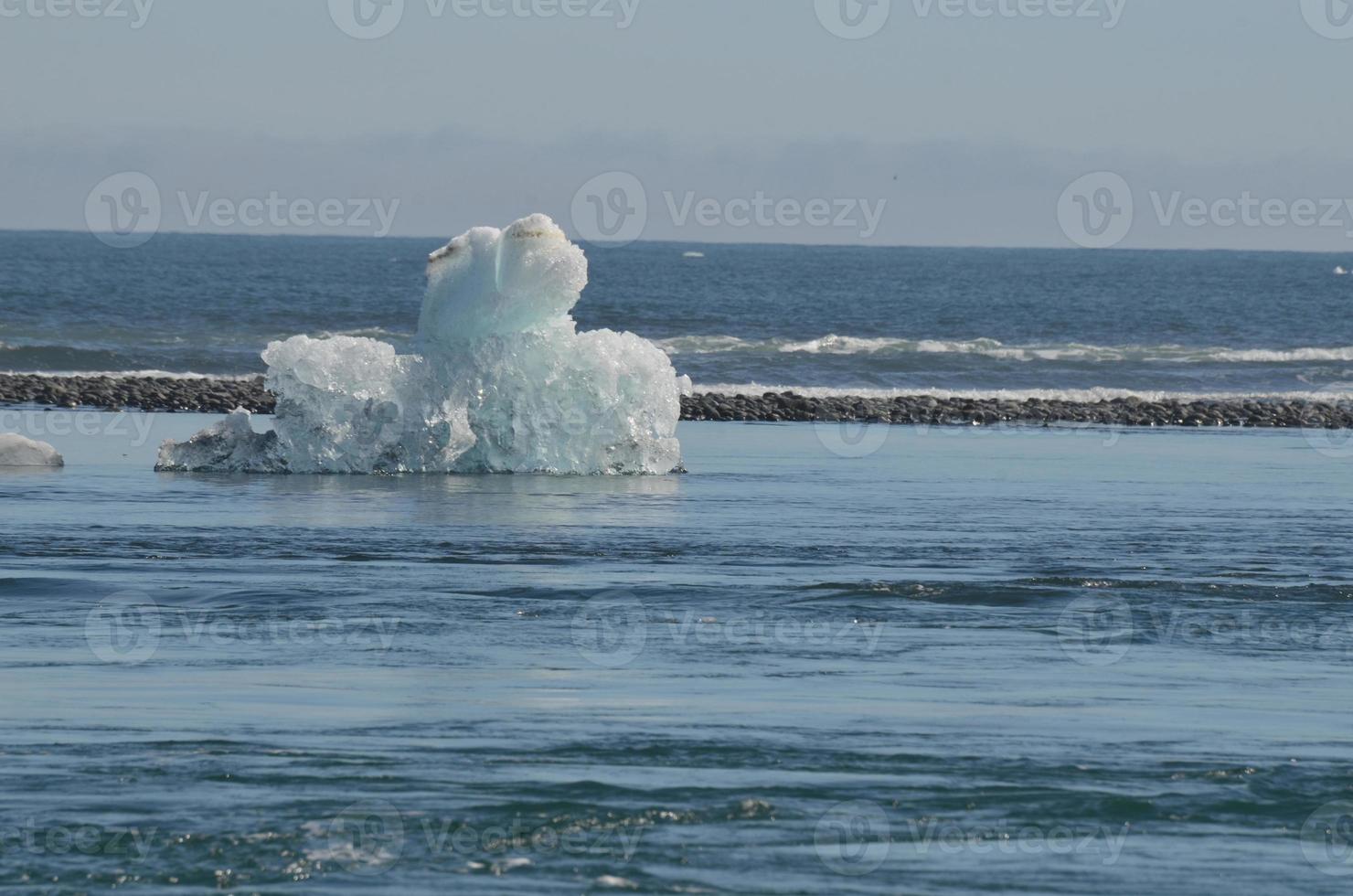 Stunning view of a unique iceberg with black sand in the background photo