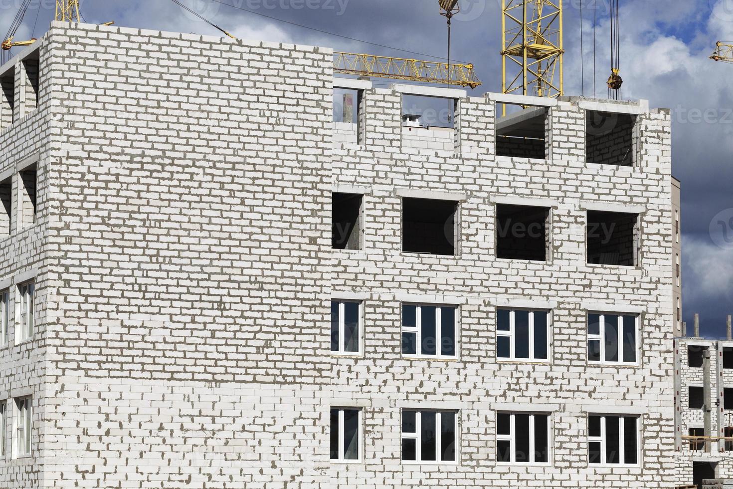 construction cranes and brick building photo